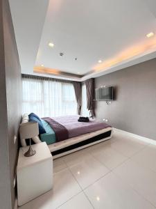 Un dormitorio con una cama grande y una ventana en Cosy Beach View Condominium en Pattaya South