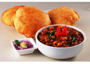 a plate of food with a bowl of stew and bread at Ashiyana Hotel in Varanasi