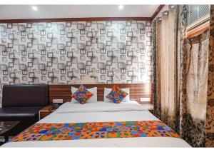 a bedroom with a bed and a couch and a wall at Ashiyana Hotel in Varanasi