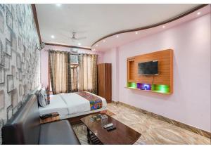 a bedroom with a bed and a couch and a table at Ashiyana Hotel in Varanasi