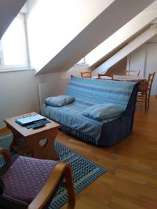 ein Schlafzimmer mit einem Bett und einem Tisch im Dachgeschoss in der Unterkunft Appartement au coeur de Luchon in Luchon