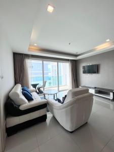 sala de estar con muebles blancos y ventana grande en Cosy Beach View Condominium, en Pattaya South