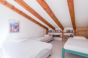 due letti in una stanza con soffitti in legno di La Tour Génoise - Climatisé avec piscine partagée a LʼÎle-Rousse Altre 15 foto