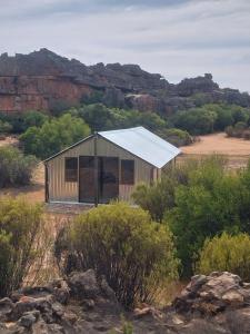 un petit bâtiment avec un toit solaire dans le désert dans l'établissement Kleinfontein, à Clanwilliam