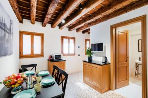 ヴェネツィアにある5 minuti da Rialto, intera palazzina Venezianaのテーブルと椅子のあるキッチンとダイニングルーム