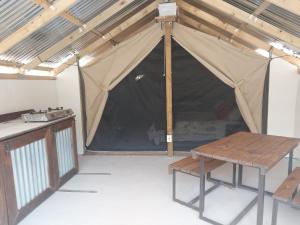 une tente avec un banc et une table. dans l'établissement Kleinfontein, à Clanwilliam
