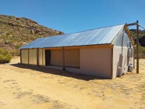 a white building with a metal roof in the desert at Kleinfontein in Clanwilliam