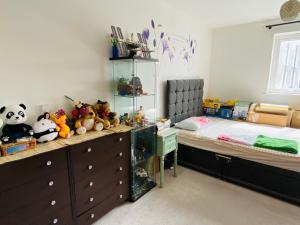 a bedroom with a bed and a desk with stuffed animals at Your ideal ExCel London- O2 Arena - LCY Airport homestay in Barking