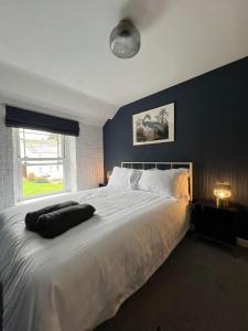 a bedroom with a large white bed with a window at Charming 2-Bed House in Llansteffan in Llanstephan