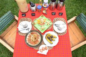 una mesa de picnic con comida en una manta roja en Room in BB - Red Rocks Rwanda - Safari Tent Twin, en Nyakinama