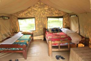 um quarto com uma cama e janelas numa tenda em Room in BB - Red Rocks Rwanda - Safari Tent Twin em Nyakinama