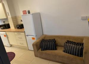 a living room with a couch and a refrigerator at Short term let Room In DE1 in Derby