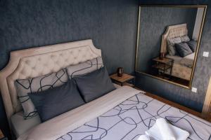 una camera da letto con un letto e un grande specchio di Lavanda a Vršac
