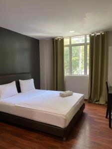 a bed in a room with a large window at 1st inn hotel subang in Subang Jaya