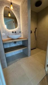 ein Bad mit einem Waschbecken und einem Spiegel in der Unterkunft Studio Lakeview in Goes