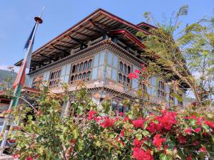 a building with red flowers in front of it at Divine heritage house in Punākha