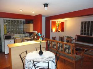 cocina con paredes rojas, mesa y sillas en Cusco's Flat, en Cusco