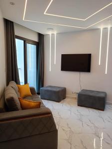 uma sala de estar com um sofá e uma televisão de ecrã plano em شاليهات فندقيه منتجع Porto said em Port Said