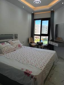 um quarto com uma cama grande e uma janela grande em شاليهات فندقيه منتجع Porto said em Port Said