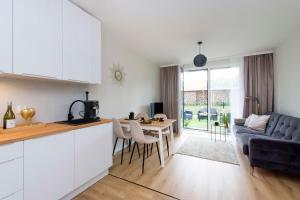 a kitchen and living room with a couch and a table at Golden Sand - Baltic Line in Gdańsk