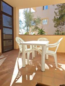 Biały stół i 2 krzesła na patio w obiekcie Casa Amarilla w mieście Es Pujols