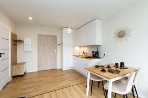 a kitchen and dining room with a table and chairs at Golden Sand - Baltic Line in Gdańsk