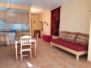 a living room with a table and a couch and a kitchen at Casa Amarilla in Es Pujols
