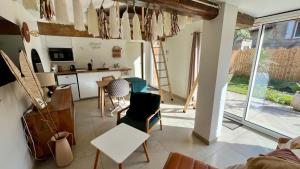 una cucina e un soggiorno con tavolo e sedie di Logement Cosy plein centre village avec mezzanines a Venerque