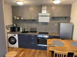 a kitchen with a stove and a sink and a table at Rohuaia 22 Apartment in Rakvere