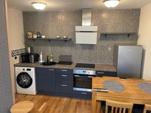 een keuken met een fornuis, een wastafel en een tafel bij Rohuaia 22 Apartment in Rakvere