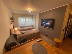 Habitación con cama, sofá y TV. en Rohuaia 22 Apartment, en Rakvere