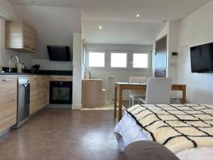 Habitación con cama y cocina con mesa en Appartement 14 - Le Lion d’Or, en Langres