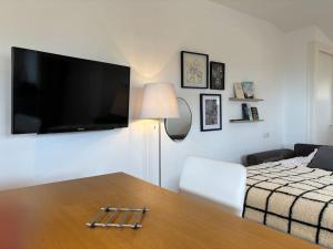 Sala de estar con cama, mesa y TV en Appartement 14 - Le Lion d’Or, en Langres