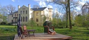 a house with a table and chairs in front of it at Herrenhaus Harmshagen in Testorf-Steinfort