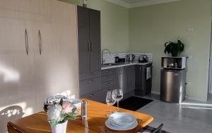 eine Küche mit einem Holztisch mit Weingläsern in der Unterkunft Sunshine Studio in Hamilton