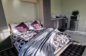 ein Schlafzimmer mit einem großen Bett mit lila Kissen in der Unterkunft Sunshine Studio in Hamilton