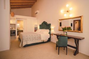 a bedroom with a bed and a desk and a mirror at Hotel Villa Giulia in Marzamemi