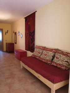 sypialnia z łóżkiem z czerwonymi poduszkami w obiekcie Casa Amarilla w mieście Es Pujols