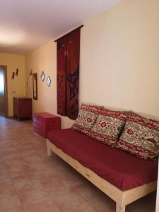 Un dormitorio con una cama con almohadas rojas. en Casa Amarilla, en Es Pujols