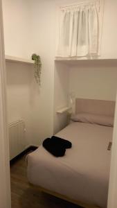 1 dormitorio con cama blanca y ventana en Apartamento Forn Vell en Sant Feliu de Guixols