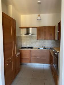 a kitchen with wooden cabinets and a stove top oven at Casa Laura in Bergamo +6 photos