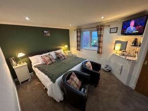 a bedroom with a large bed and a flat screen tv at Southpark House in Dumfries