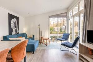 a living room with a blue couch and chairs at Summio Landgoed Het Grote Zand in Hooghalen