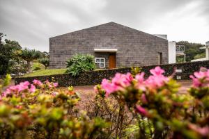 uma casa com flores cor-de-rosa em frente em ANC Resort em Caloura