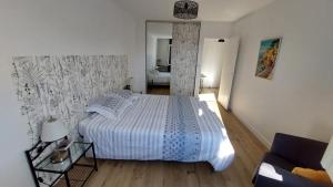 a bedroom with a large bed and a mirror at Maison au coeur de Meschers - proche des plages in Meschers-sur-Gironde