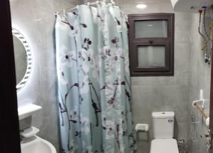 a bathroom with a shower curtain with a toilet at شاليهات فندقيه بورتوسعيد in Port Said