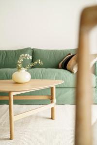 a coffee table in a living room with a green couch at Racons - La Placeta in Vic
