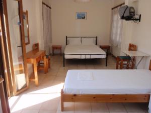 a bedroom with two beds and a table and chairs at Vazakas Rooms in Mytilene