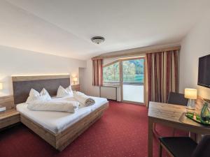 a hotel room with a bed and a large window at Hotel Forelle in Plansee