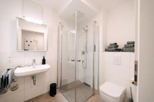 uma casa de banho com um chuveiro, um WC e um lavatório. em ZENtrahome - Balkon Outlet Zentral SmartTV Business em Metzingen